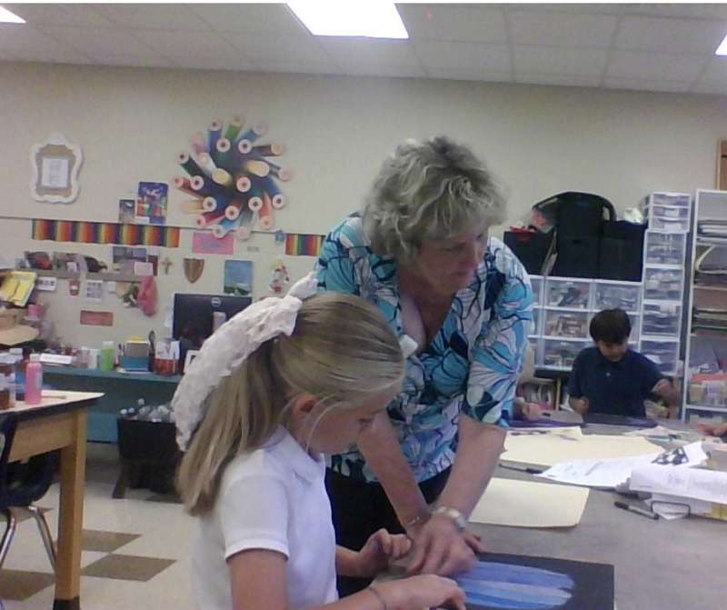 art teacher helping student at table
