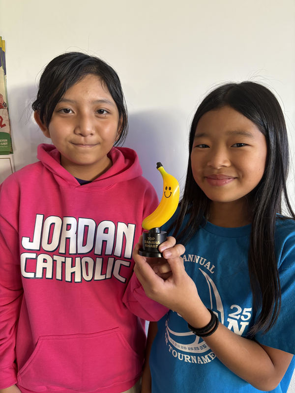 students posing with banana trophy