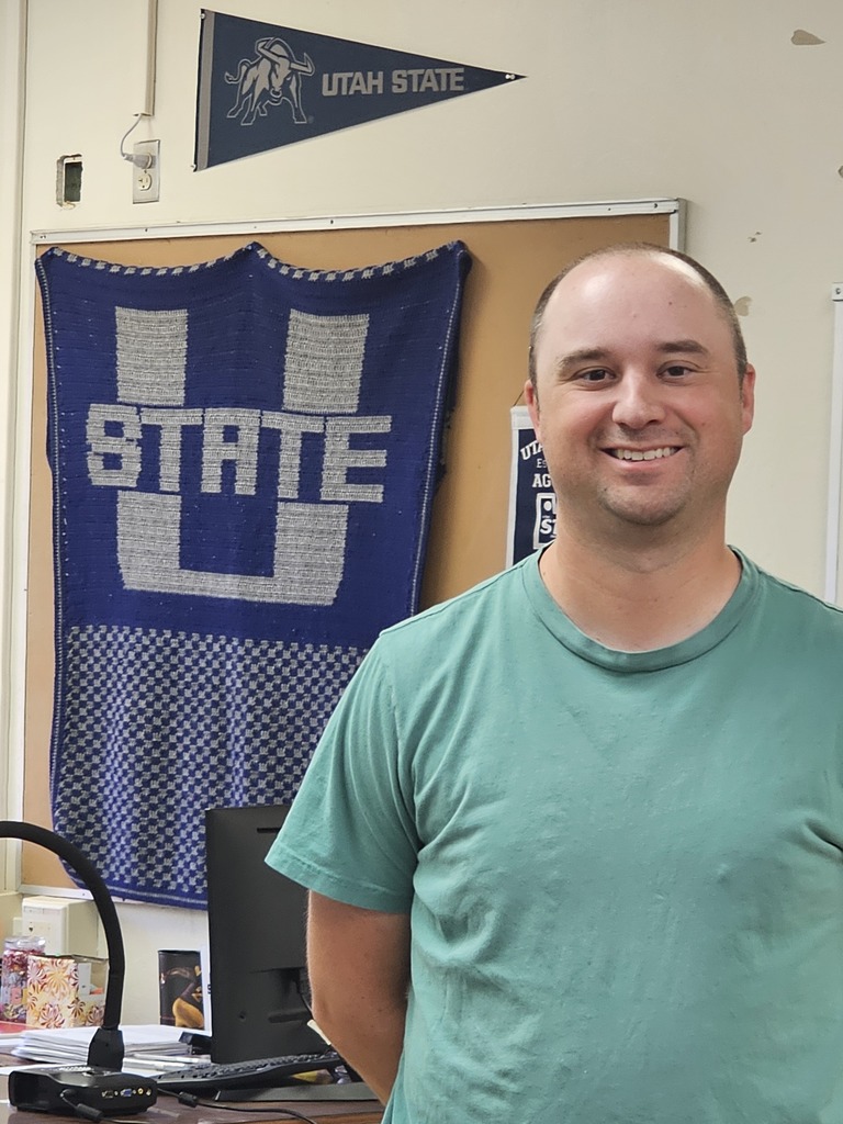 Mr. Murphy standing in front of a U State banner.