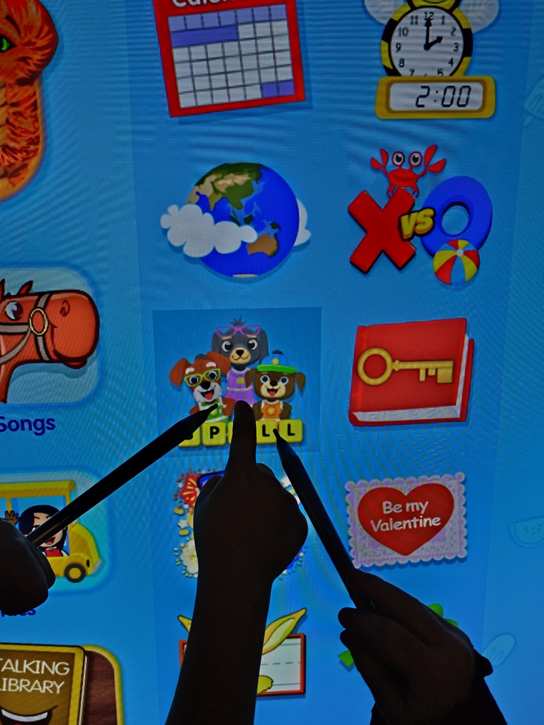 Students pointing to spelling games in starfall.