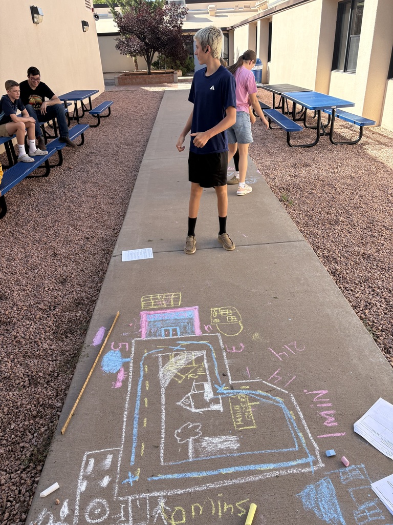 Geometry students using sidewalk chalk to draw their city designs