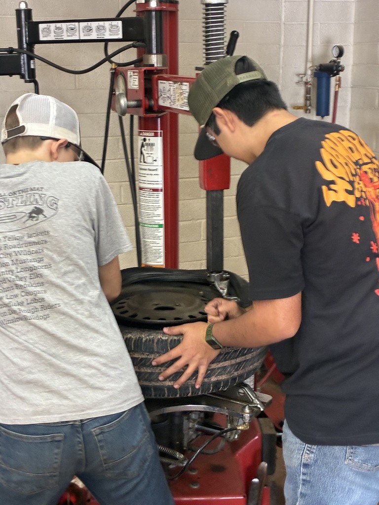 Matthew and Axton learning to use the tire machine