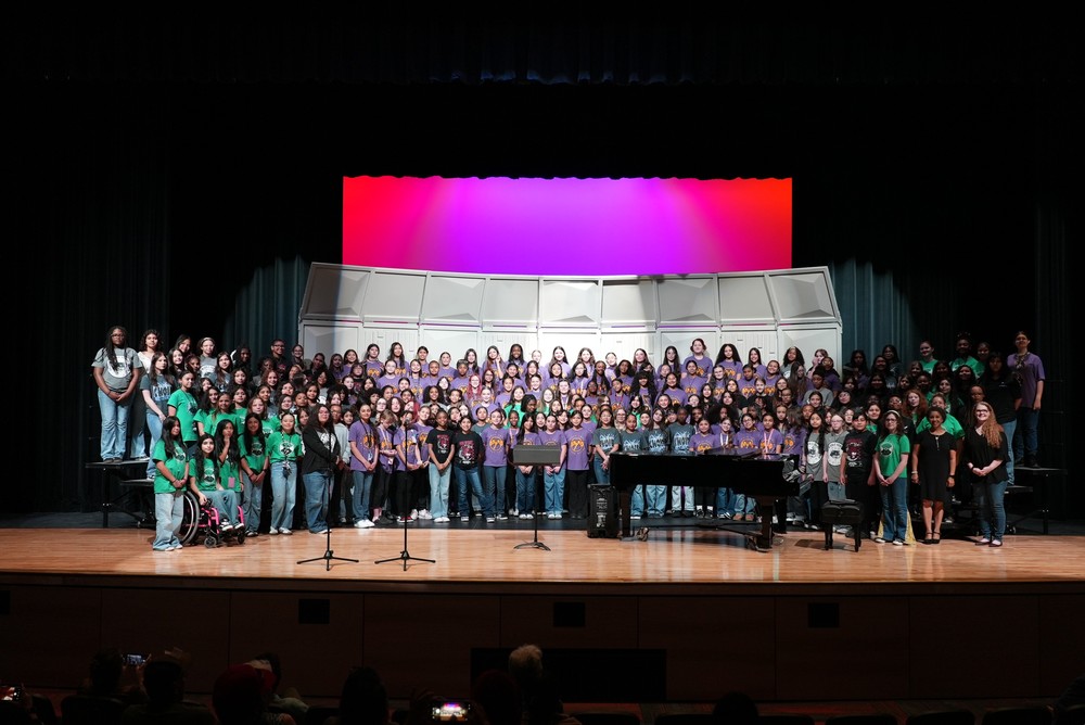 A choir on a stage standing on risers