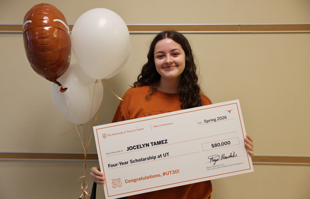 Female student with presentation check for 80,000 for UT Scholarship