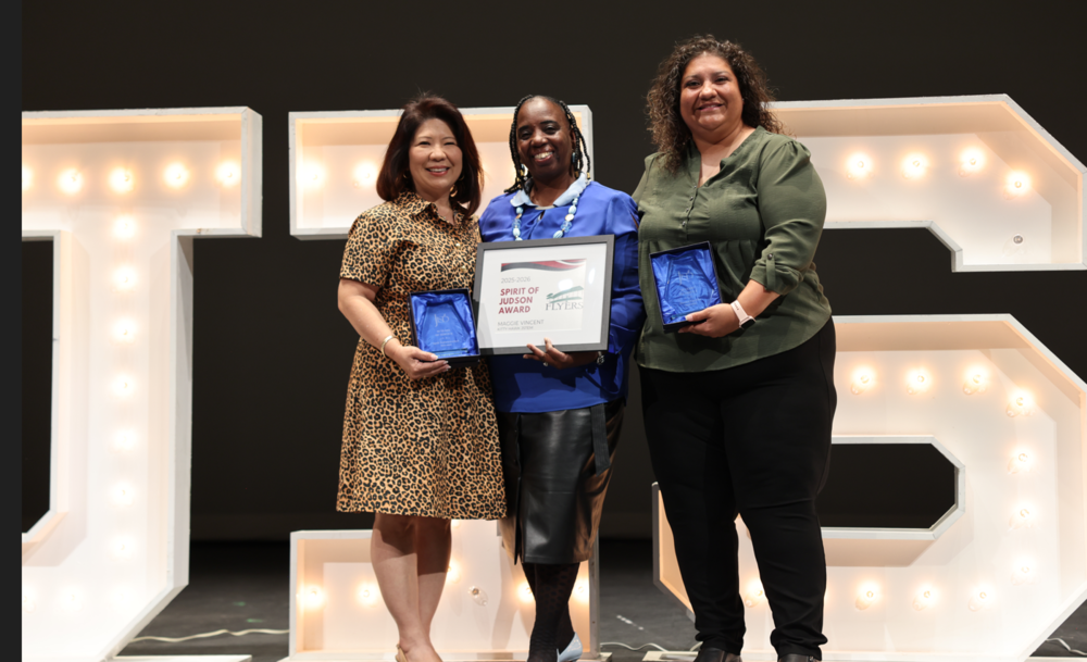 Three ladies standing in front of JISD letters holding awards