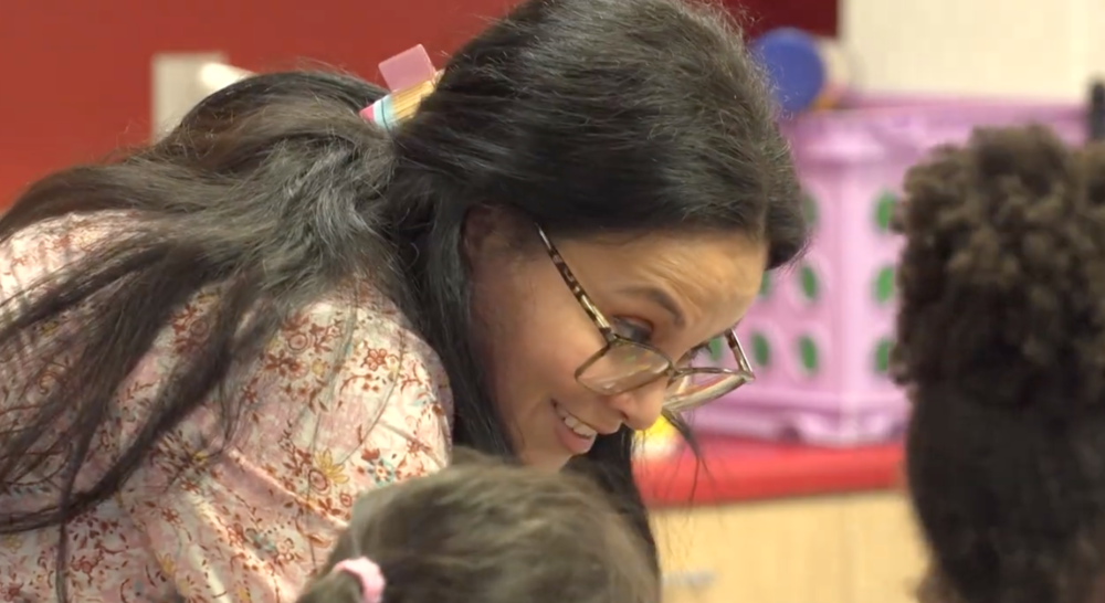 Woman smiling at students.