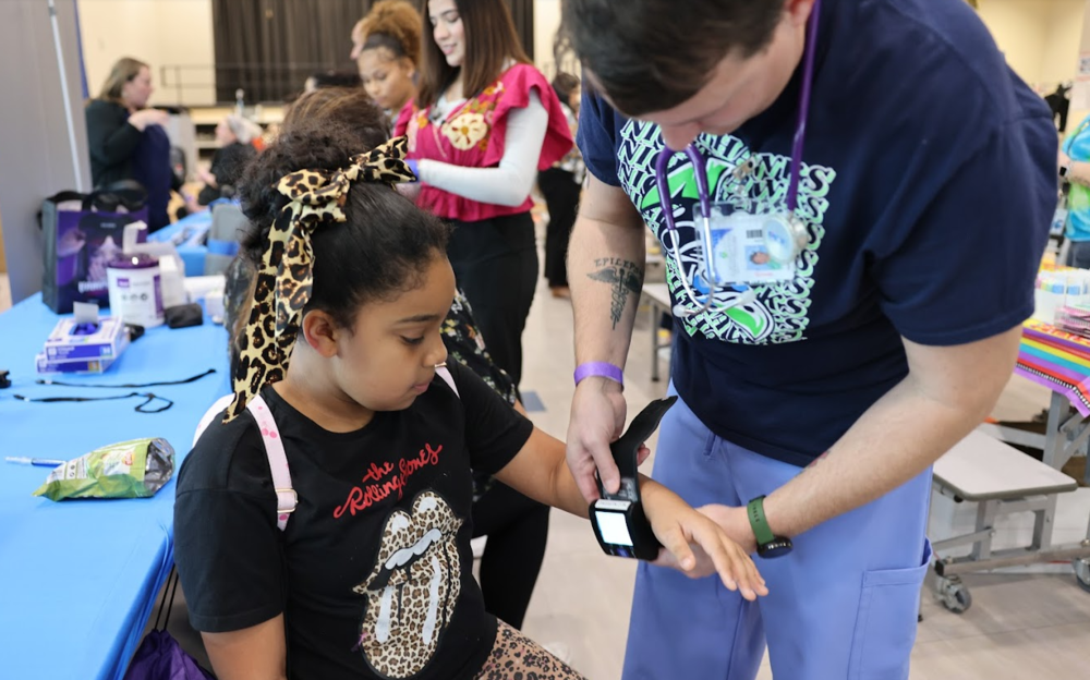 Little girl with nurse getting her pulse checked.