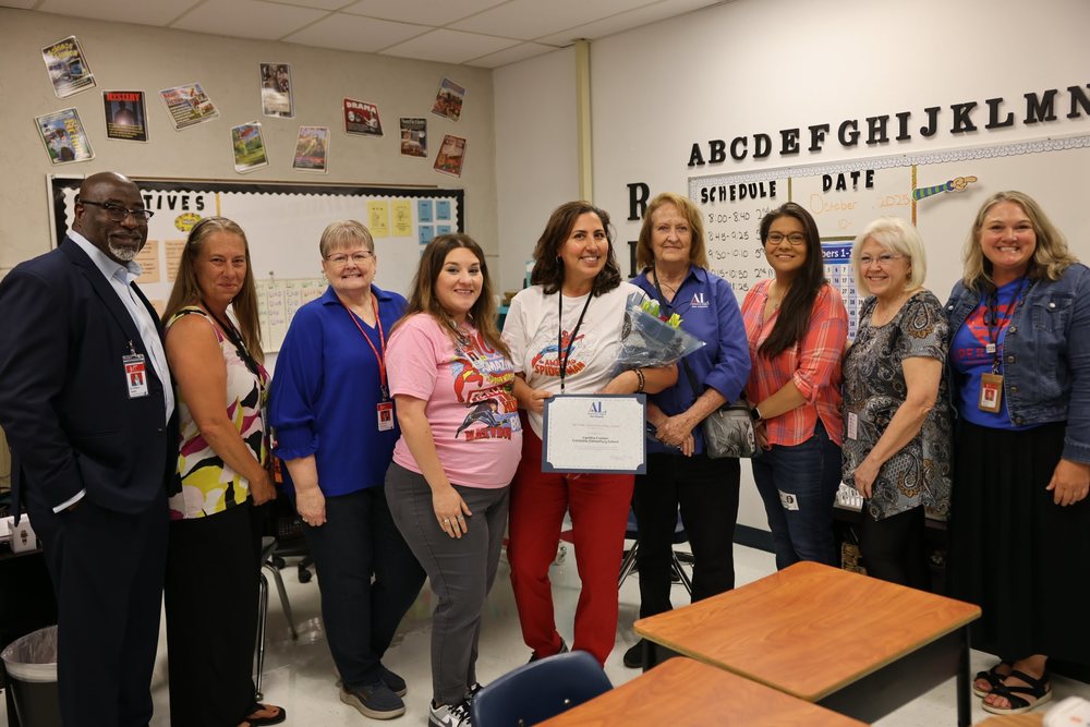 Teacher holding a certificate standing with Leadership