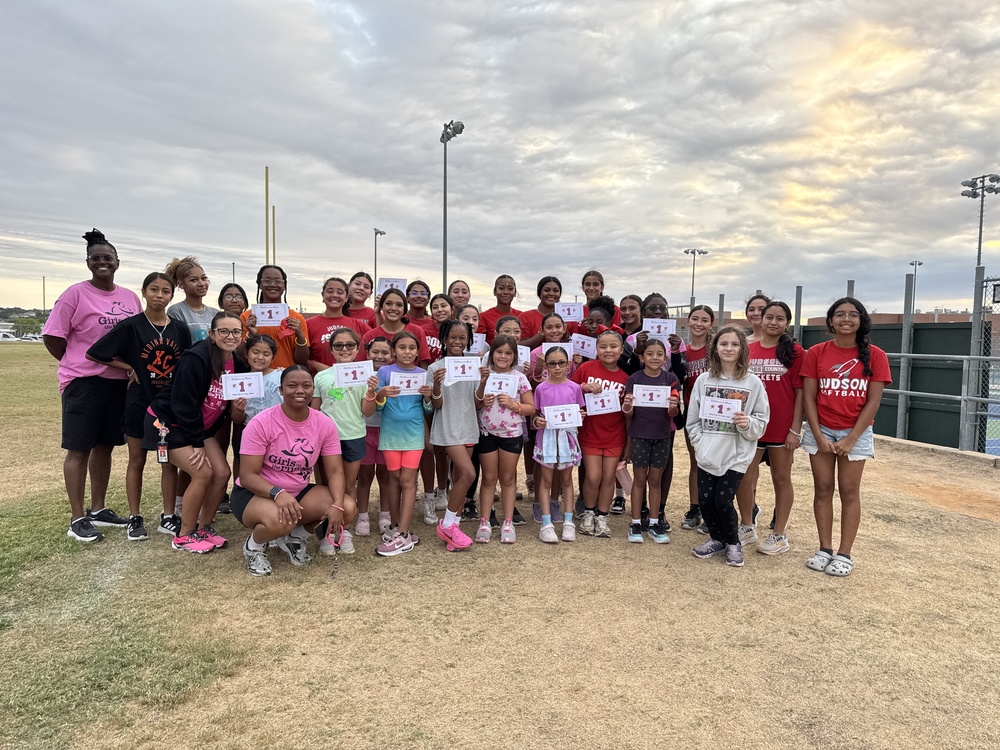 Young girls holding certificates standing with coaches and high school athletes