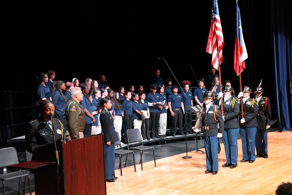 Students on stage with flags and military uniforms