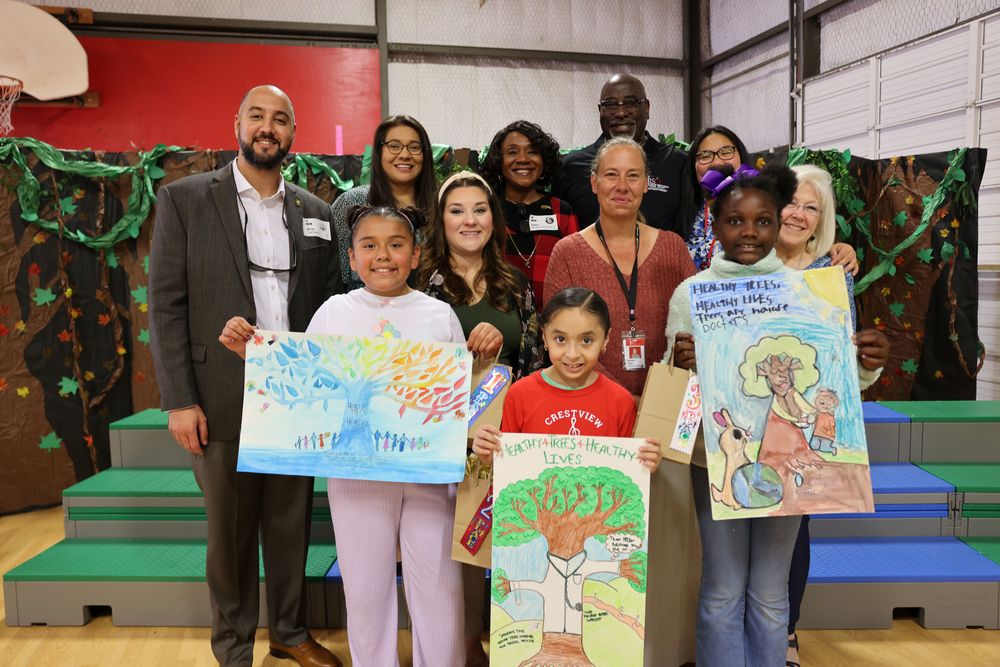 Adults with students holding posters