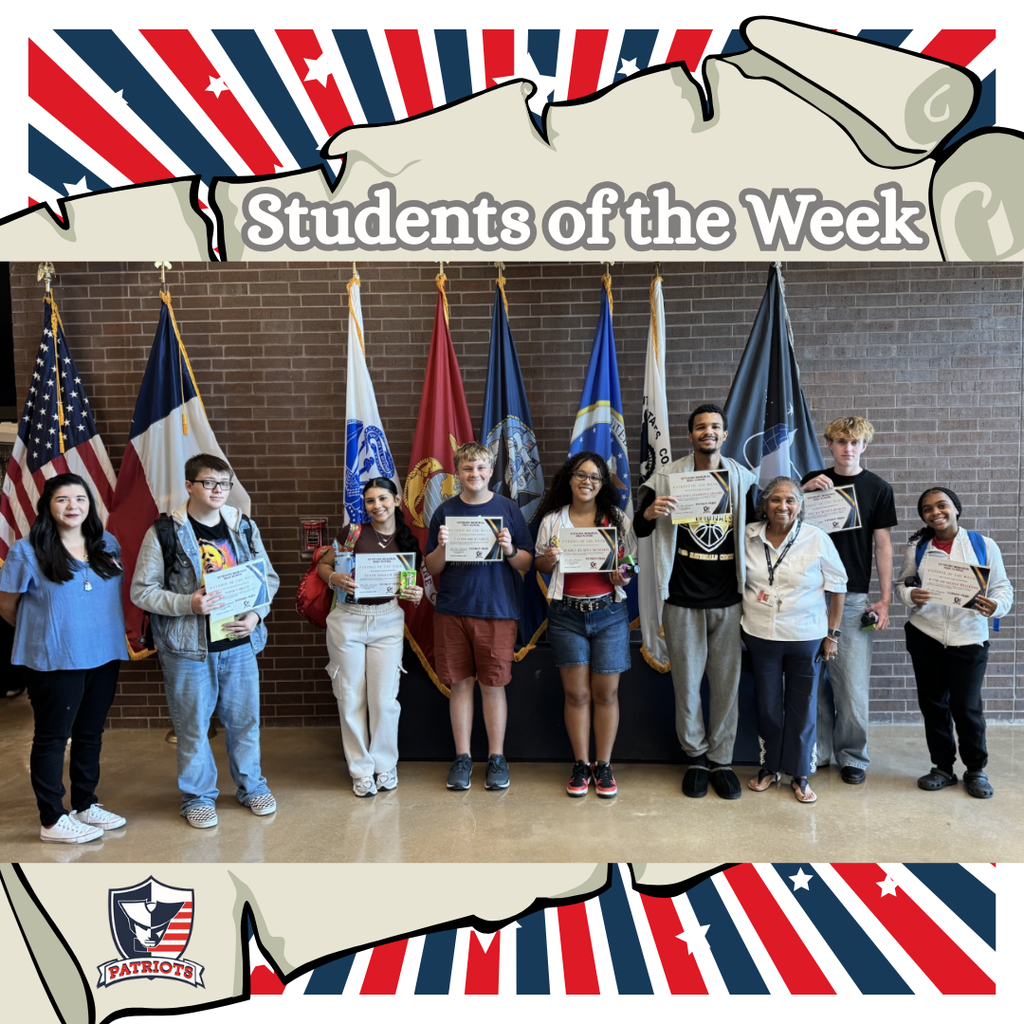 Seven students standing with two staff members in front of the flags in the VMHS foyer