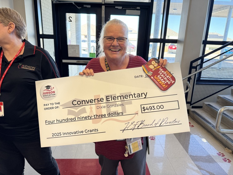 teacher standing with a check