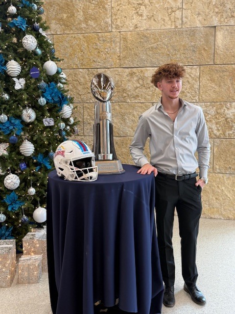 Image of Blake posing by the trophy