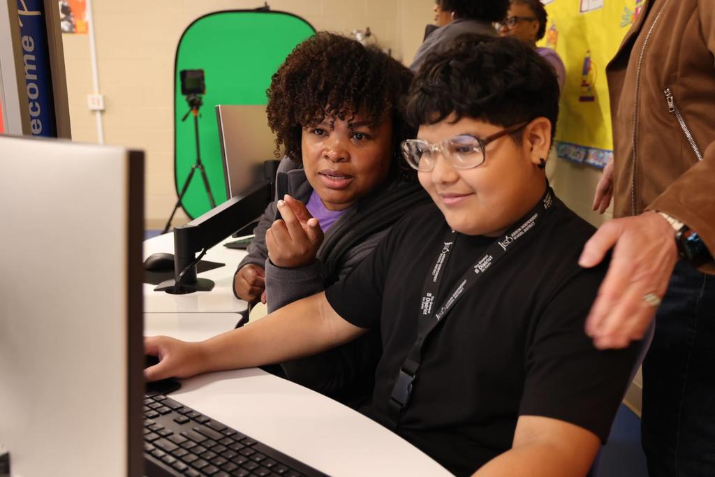 Student and teacher looking at a computer