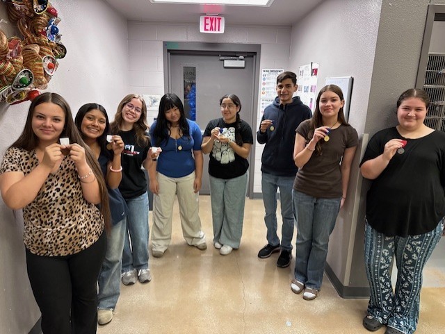 Orchestra students showing off their medals