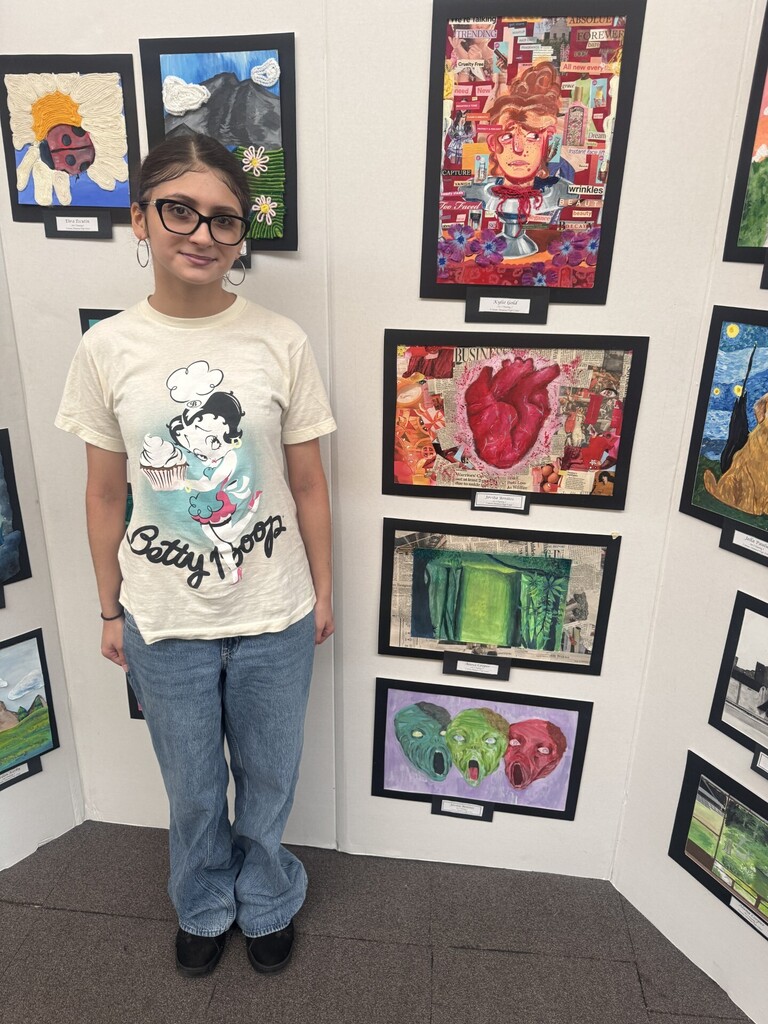 Student stands with artwork