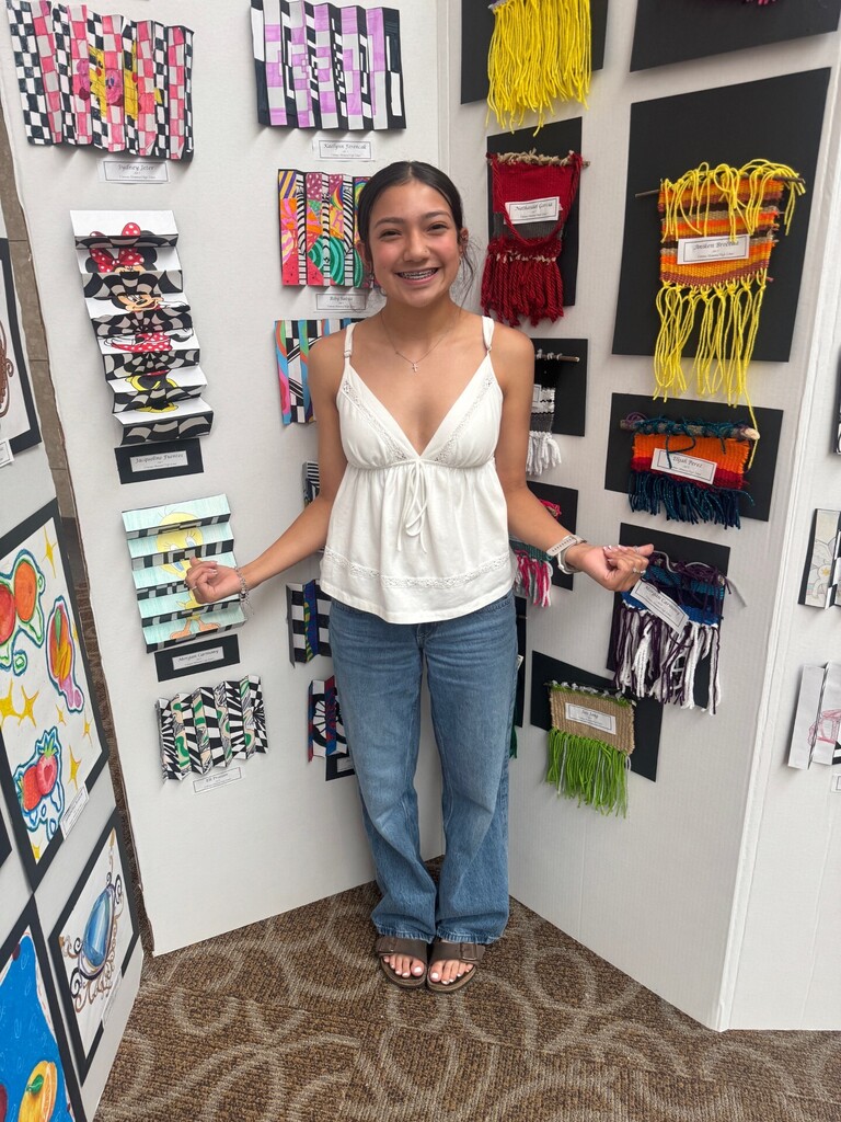 Student stands with artwork