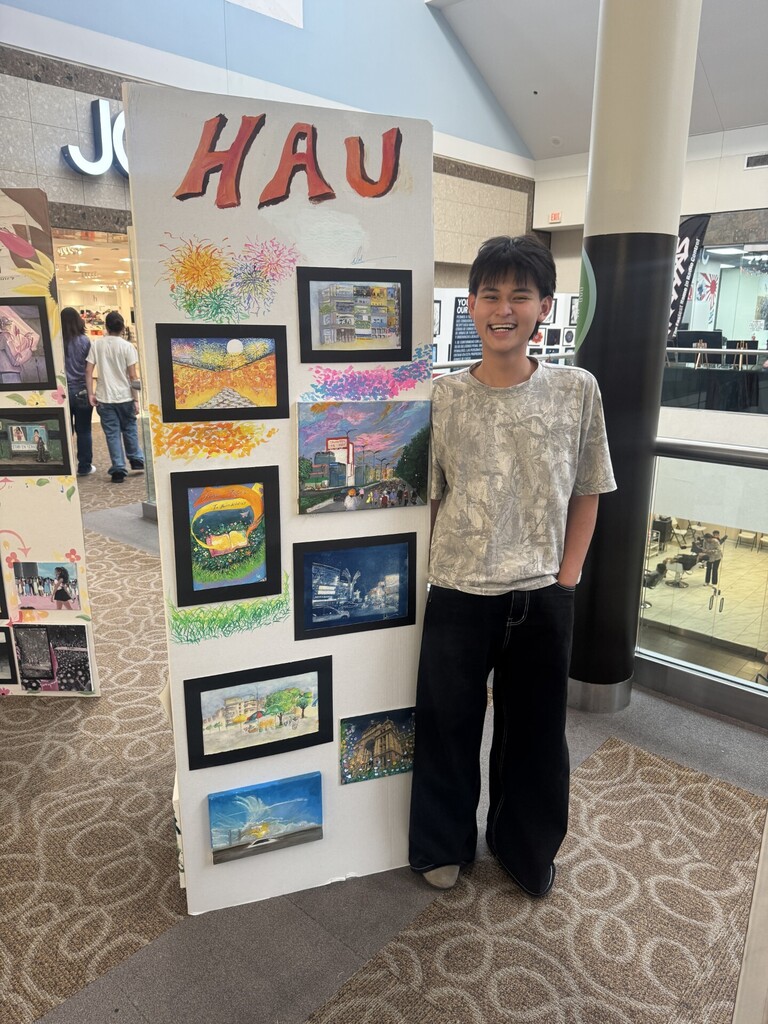 Student stands with artwork
