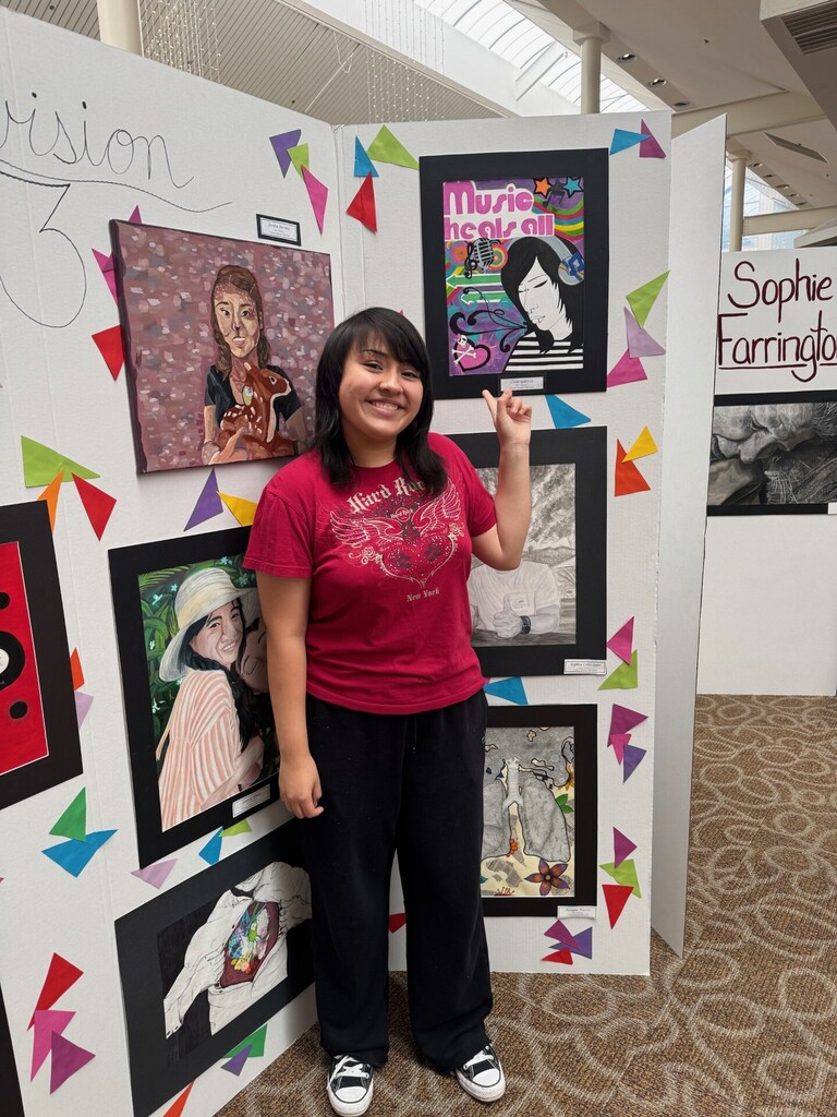 Student stands with artwork