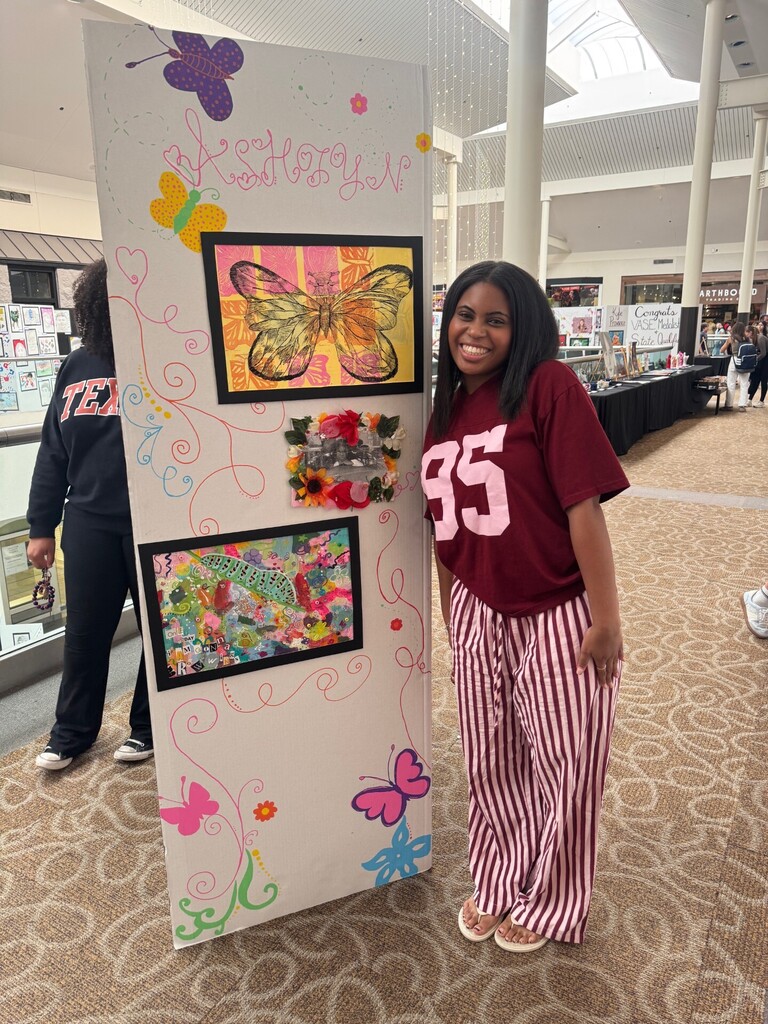 Student stands with artwork