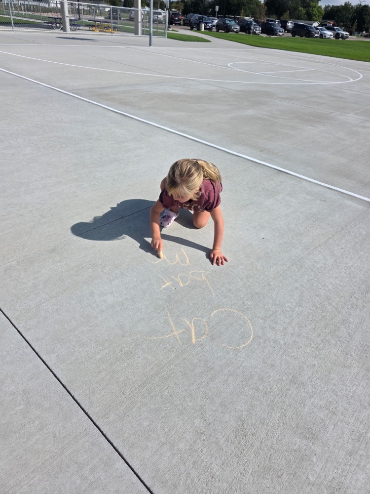 Practicing spelling words with sidewalk chalk.