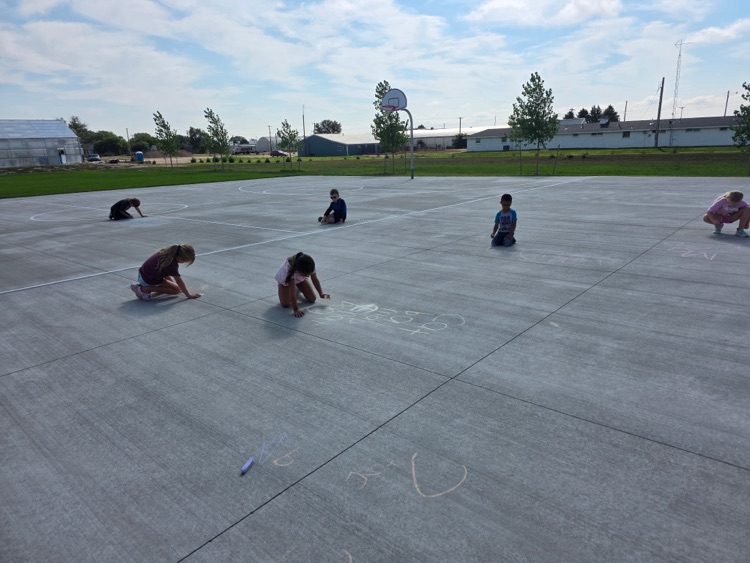 Practicing spelling words with sidewalk chalk.