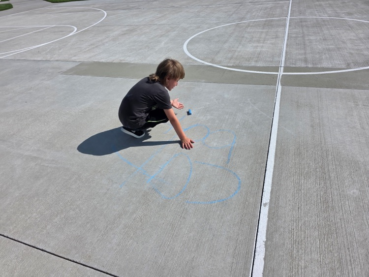 Practicing spelling words with sidewalk chalk.