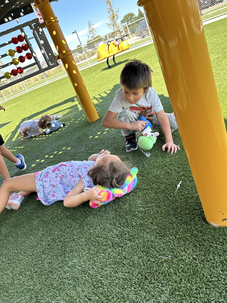a boy and girl playing with their teddy bears at recess