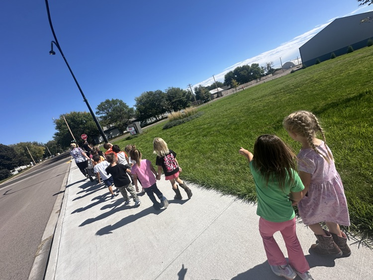 preschool students and staff walking down sidewalk