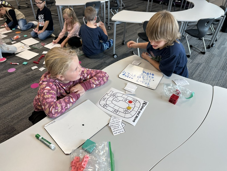 Students working on addition word problems to win a board game
