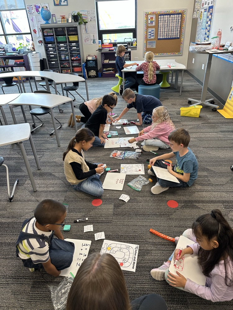 Students working on addition word problems to win a board game