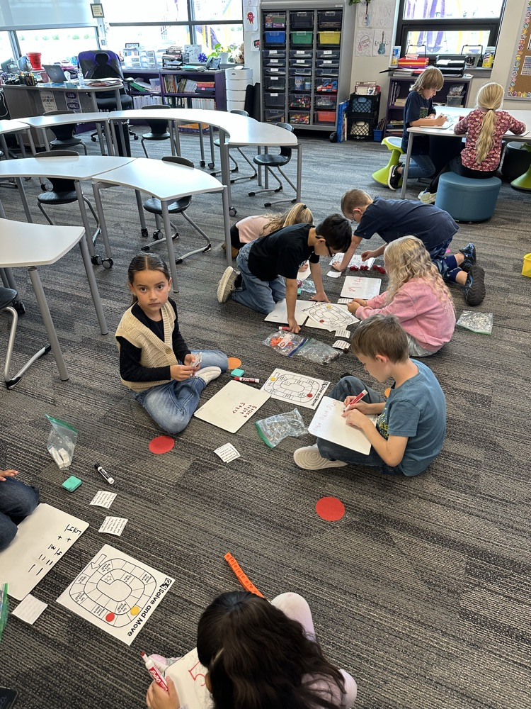 Students working on addition word problems to win a board game.