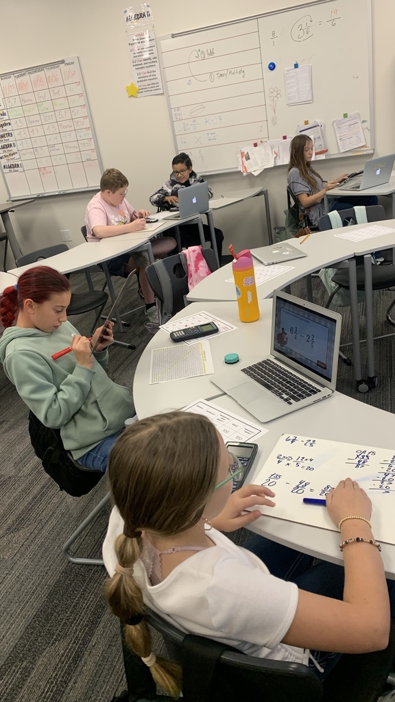 students can be seen practicing problems by using whiteboards!