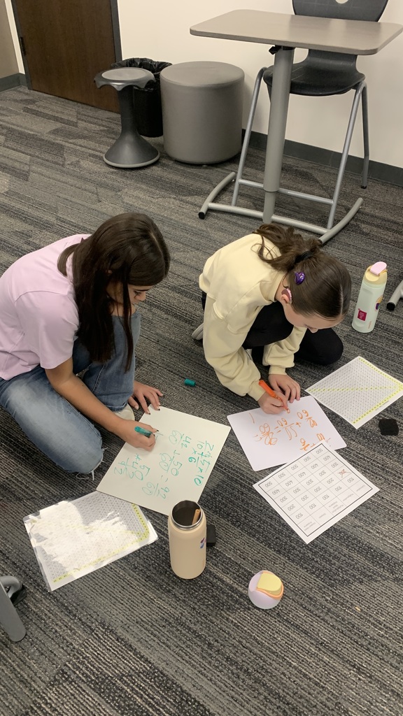 two students working independently on their whiteboards to make sure they have the correct answer