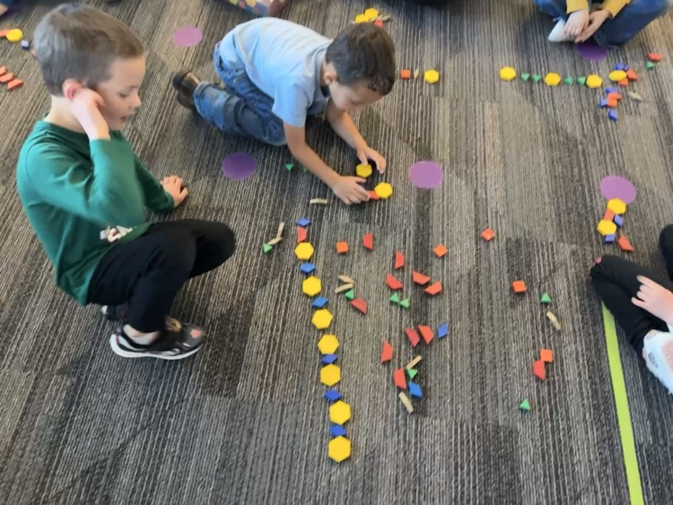 students using pattern blocks to create color patterns 