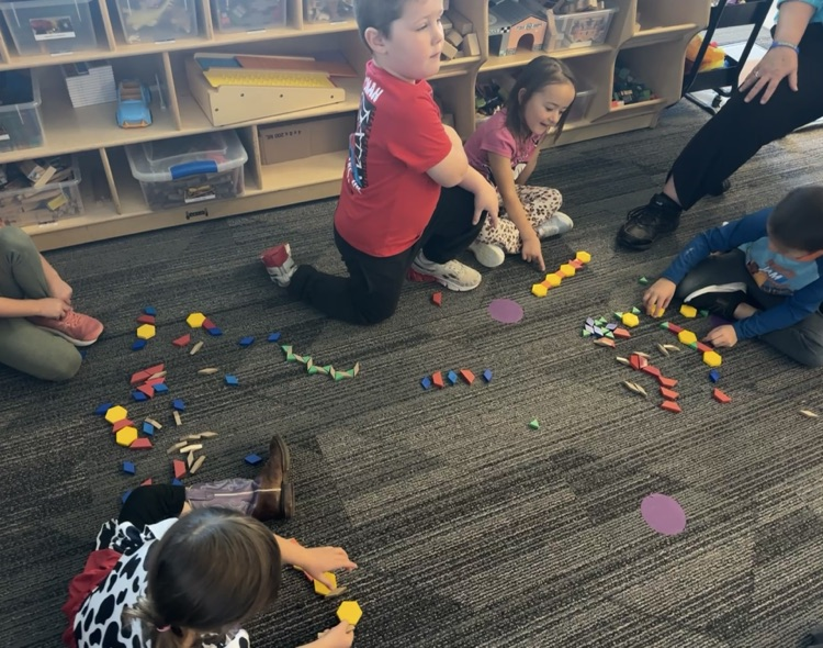 students using pattern blocks to create color patterns 