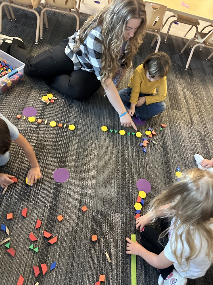 students using pattern blocks to create color patterns 