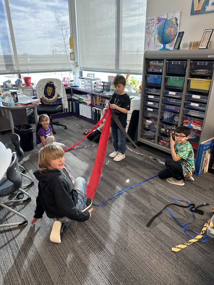 1st graders finishing their unit on Geometry by building 3-D objects with tied and ribbons.