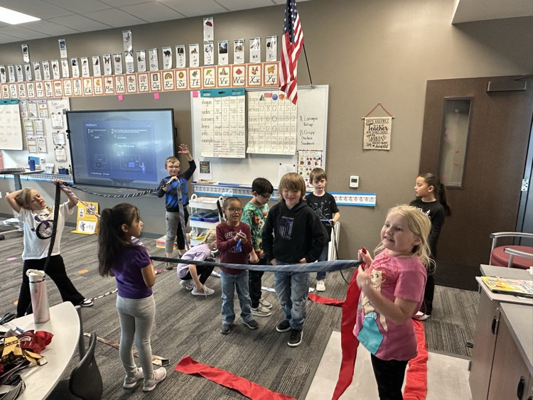 1st graders finishing their unit on Geometry by building 3-D objects with tied and ribbons.