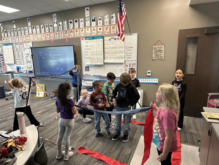 1st graders finishing their unit on Geometry by building 3-D objects with tied and ribbons.