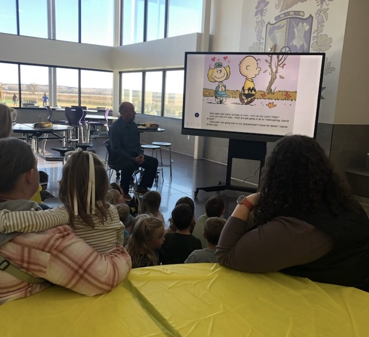 students and families listening to the reading of Charlie Brown Thanksgiving 