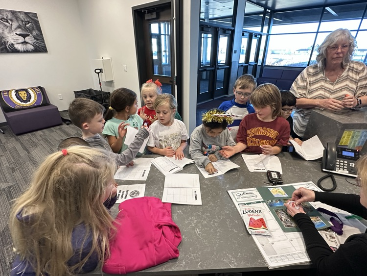 Students collecting their stamp on their passports from Mrs. Lechman. 