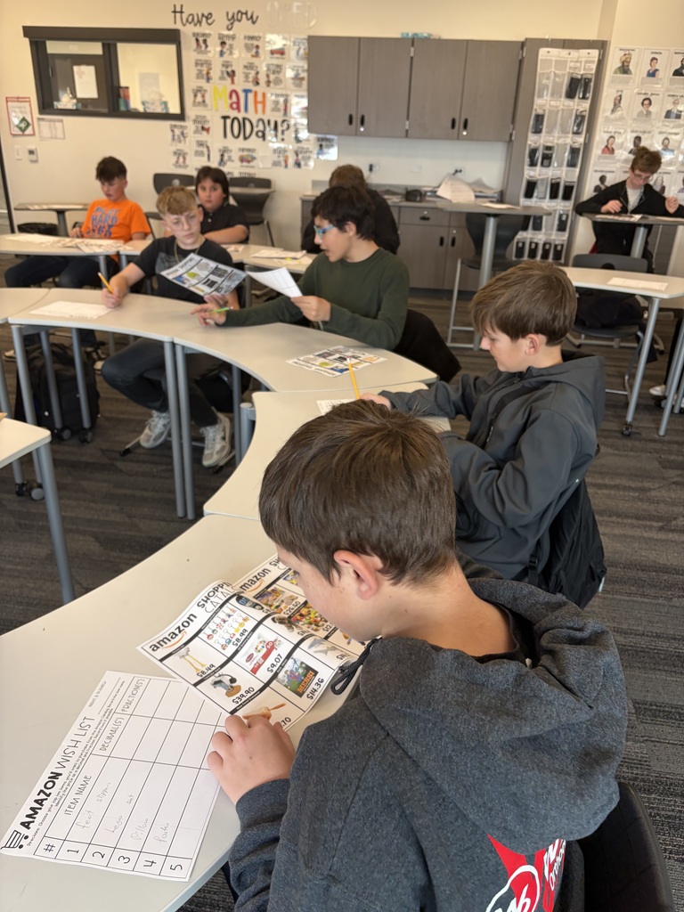 studnets looking through a catalog as they look for their top 10 items to shop! Even some students compare their options