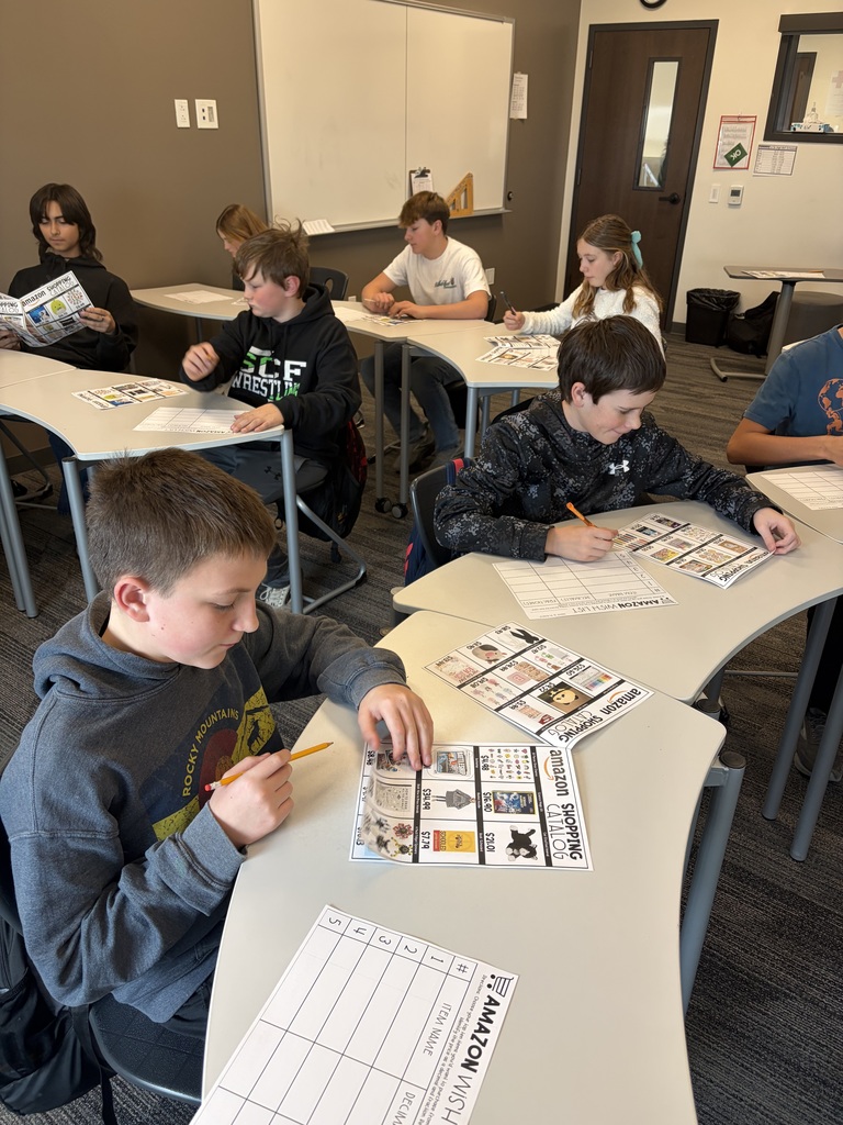 studnets looking through a catalog as they look for their top 10 items to shop!