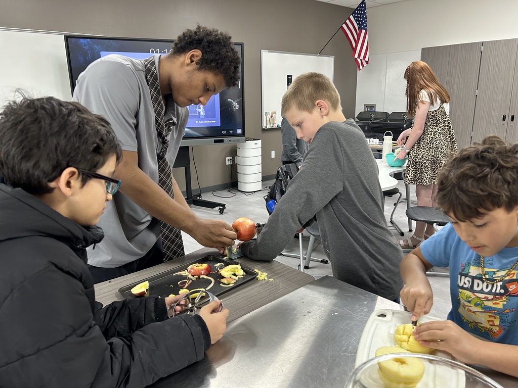 Students slice and peal the apple.