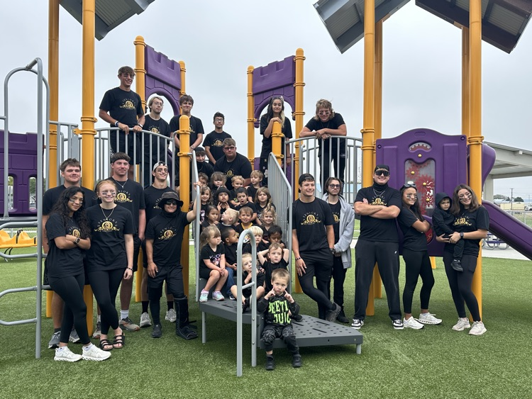 Seniors and preschool students on the playground in all black for color war day