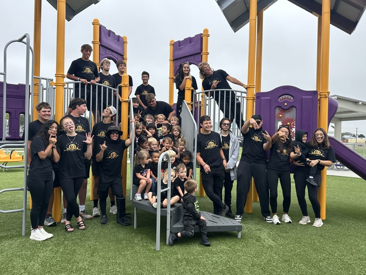 Seniors and preschool students on the playground in all black for color war day