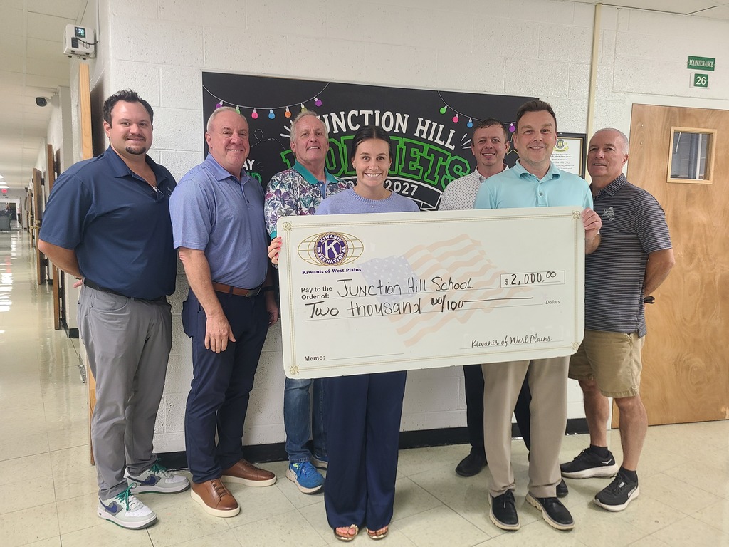Kiwanis club members present School Administration with an oversized check for 2000 dollars. A donation for playground equipment!