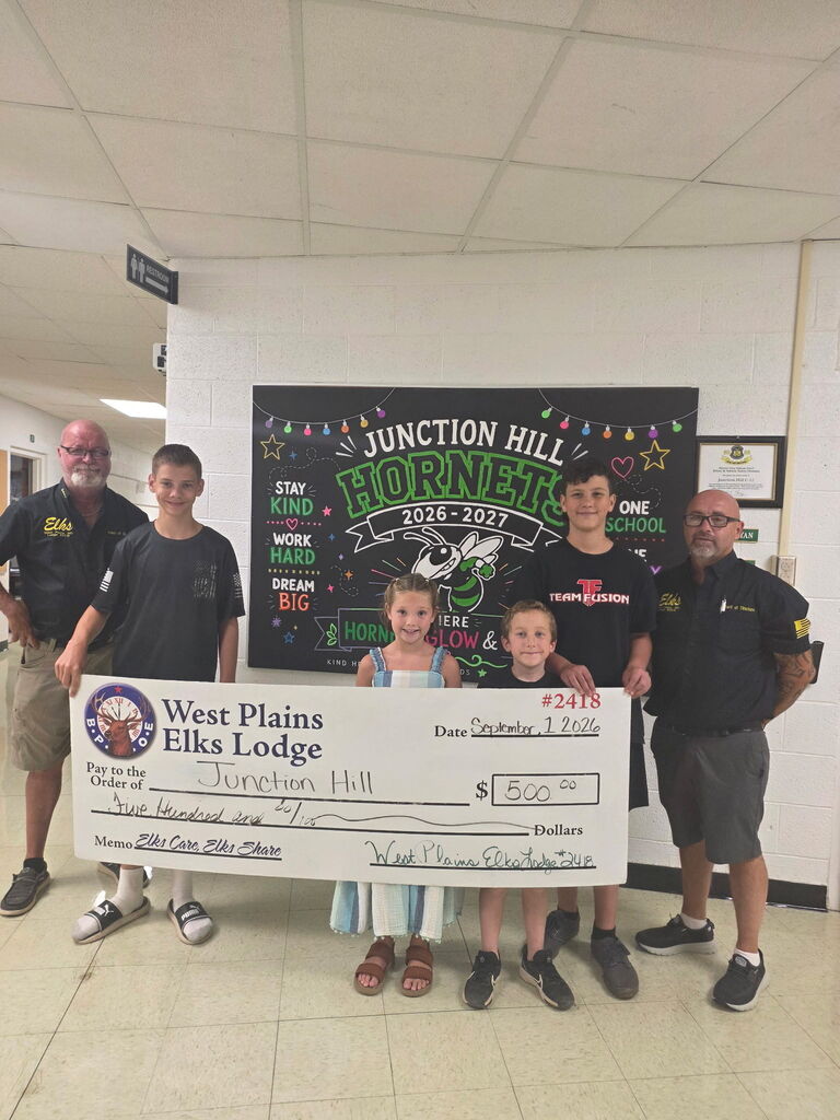 four students and two eld lodge members are presenting a giant oversized 500.00 check to Junction Hill School from the West Plains Elks' Lodge